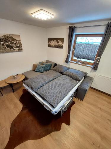 a bedroom with a bed and a couch and a window at Ferienwohnung Frieda in Ellmau
