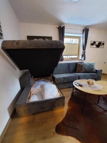 a bed in a living room with a couch and a table at Ferienwohnung Frieda in Ellmau