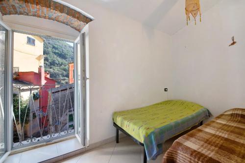 1 dormitorio con cama y ventana grande en Serra Trilocale, en Bonassola