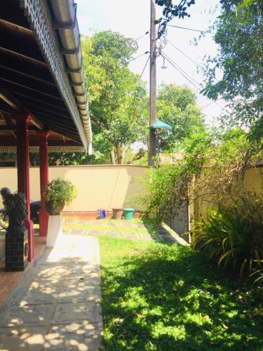 un patio de una casa con una acera y césped en Villa 5, en Ambalangoda