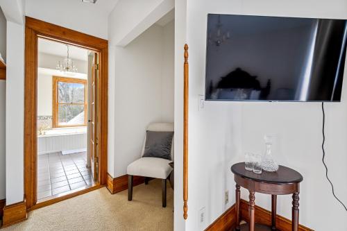 a hallway with a table and a chair and a television at Stratton Creek Inn in Stratton
