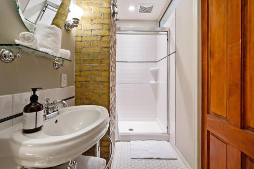 a white bathroom with a sink and a shower at Stratton Creek Inn in Stratton