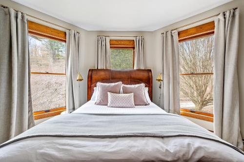 a bedroom with a large bed and two windows at Stratton Creek Inn in Stratton
