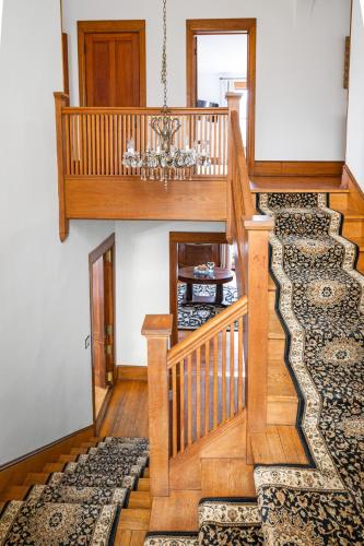 a wooden staircase with a chandelier in a house at Stratton Creek Inn in Stratton