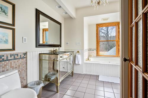 La salle de bains est pourvue d'une baignoire, d'un lavabo et d'un miroir. dans l'établissement Stratton Creek Inn, 