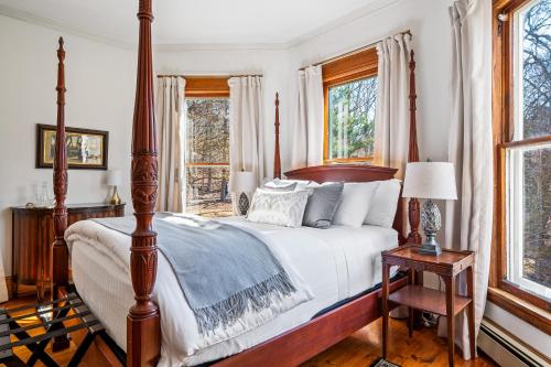 a bedroom with a four poster bed and windows at Stratton Creek Inn in Stratton