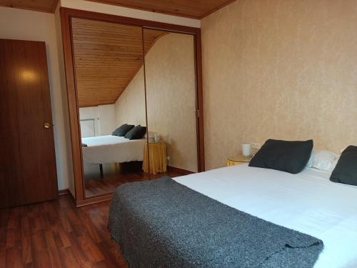 カンプロドンにあるApartament Duplex Camprodonのベッドルーム(大きな鏡、ベッド付)