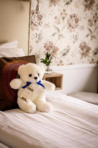 a white teddy bear sitting on a bed at Freys Hotel in Stockholm