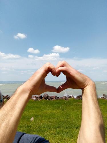 a man making a heart with his hands at Chill & Relax Apartment in Siófok