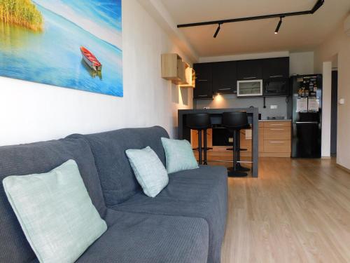 a living room with a couch and a kitchen at Chill & Relax Apartment in Siófok