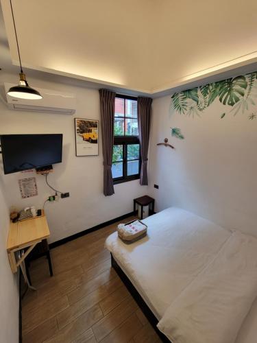OLD WOW Shared Homestay في لونغتان: غرفة نوم بسرير ومكتب وتلفزيون