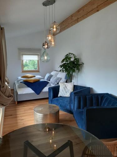 a living room with a blue couch and a bed at Studio mit großer Loggia in Saalfelden am Steinernen Meer