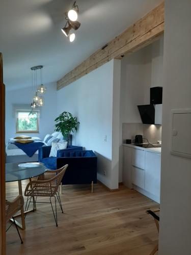 Una sala de estar con una mesa y una cocina. en Studio mit großer Loggia, en Saalfelden am Steinernen Meer
