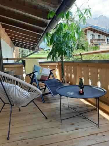 Un patio con sillas y una mesa en una terraza. en Studio mit großer Loggia, en Saalfelden am Steinernen Meer