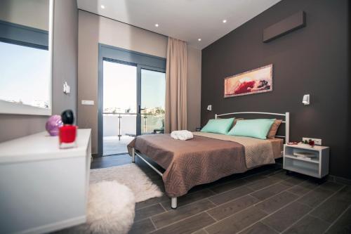 - une chambre avec un lit et une grande fenêtre dans l'établissement Calma Apartment, à Rhodes