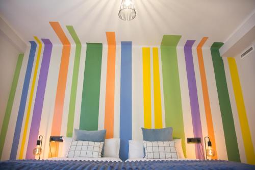 Habitación con cama con paredes a rayas de colores. en Tauste Centro - Piso, en Tauste