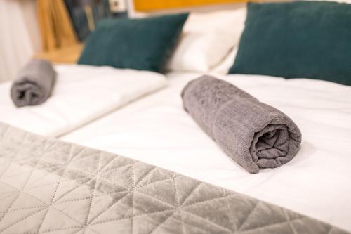 zwei gewalzte Handtücher auf einem Bett in der Unterkunft Prime Apartments City Center in Suceava