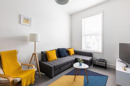 a living room with a couch and a tv at Judah Suites - Stylish 1BR Apartments with Parking & WIFI in Barry