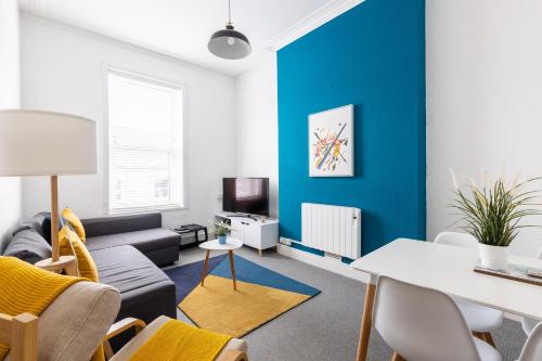 a living room with a blue accent wall at Judah Suites - Stylish 1BR Apartments with Parking & WIFI in Barry