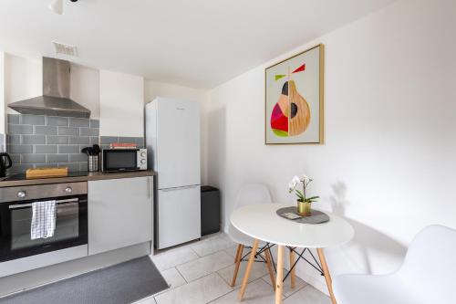 uma cozinha com electrodomésticos brancos e uma mesa branca em Judah Suites by Koya Homes em Barry