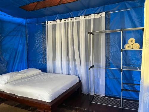 a bedroom with a blue tent with a bed at Hacienda Rio Oro in Agua Buena