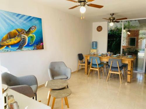 un comedor con una pintura de tortuga en la pared en Casa ideal vacaciones o trabajo, en Santa Marta