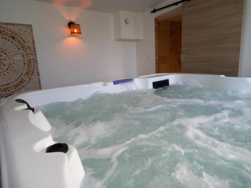 a bath tub filled with water in a bathroom at Le gite de Fa nny Moulin de Tartay en Avignon in Avignon