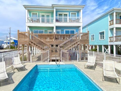 a villa with a swimming pool and a house at Blue Parrot in Gulf Shores