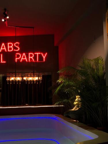 - un signe néon indiquant une fête dans la salle avec une piscine dans l'établissement ABS Pool Condo, à Nanwan