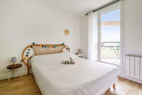 a bedroom with a large bed with a wooden headboard at Charming 1br with terrace close to Paris - Asnières - Welkeys in Asnières-sur-Seine