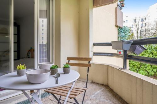 a small table on a balcony with plants on it at Charming 1br with terrace close to Paris - Asnières - Welkeys in Asnières-sur-Seine