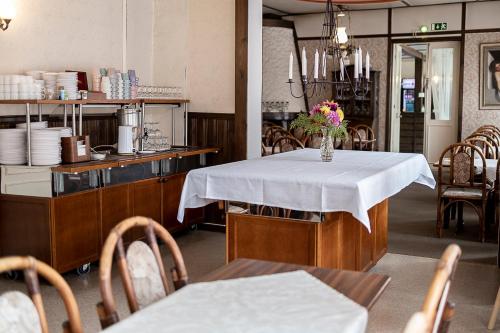 a dining room with a table with a vase of flowers on it at Aurantola in Jaala