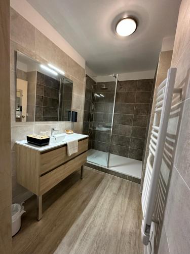een badkamer met een wastafel en een douche bij Logis Hôtels - Hôtel et Restaurant Le Lion d'Or in Gramat