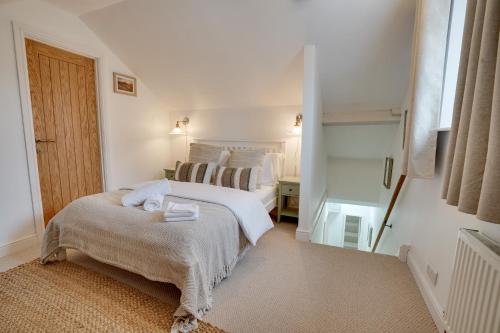 ein weißes Schlafzimmer mit einem Bett und einem Fenster in der Unterkunft Sage Cottage Buxton Family Getaway with Log Fire in Buxton