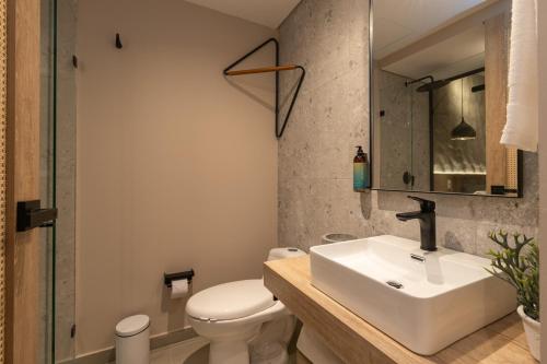 a bathroom with a sink and a toilet and a mirror at Landmark Hotel in Medellín