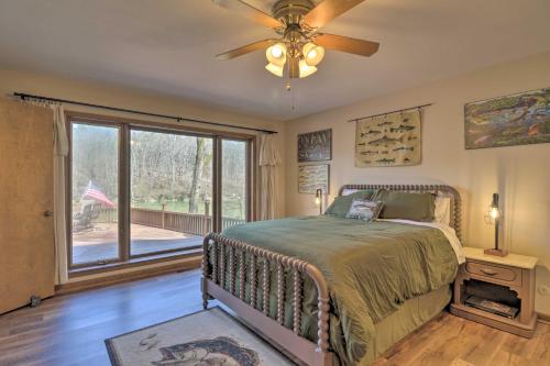ein Schlafzimmer mit einem Bett und einem großen Fenster in der Unterkunft Riverfront Retreat with Fire Pit Fish and Hike! in Heber Springs