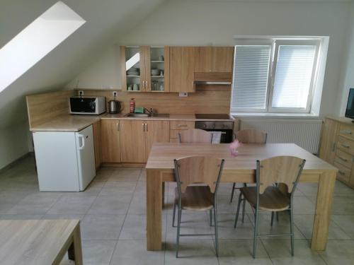 a kitchen with a wooden table and chairs at Ubytování AVEPO in Borohrádek
