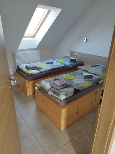 two twin beds in a room with a window at Ubytování AVEPO in Borohrádek
