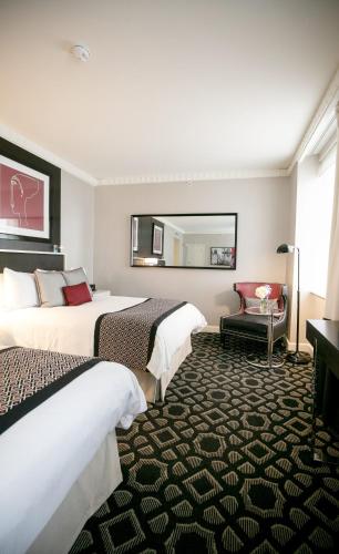 a hotel room with two beds and a mirror at Sofitel Lafayette Square Washington DC in Washington