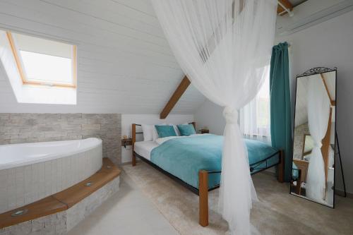 een slaapkamer met een bed, een bad en een raam bij Lotti Residence Romantik in Balatonfüred