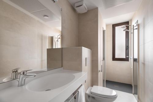 uma casa de banho branca com um lavatório e um WC em Apartamentos Suite The Way em Astorga