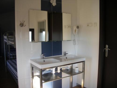 La salle de bains est pourvue d'un lavabo blanc et d'un miroir. dans l'établissement Hostel El Castillo, à Aniñon
