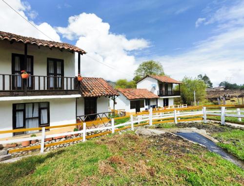 a group of houses with a white fence at La Posada Campestre Cabañas in El Cocuy