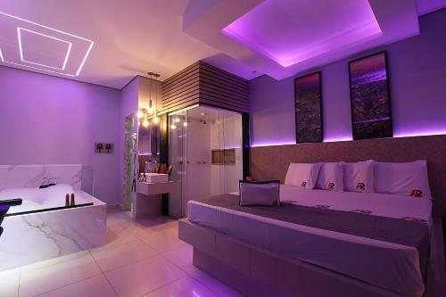 a purple bedroom with a bed and a bathroom at A2 Motel in Ribeirão Preto