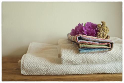 una pila de toallas y una flor morada en una mesa en Dom Pod Lipami, en Blatnica