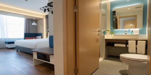 乌鲁木齐Holiday Inn Express Urumqi Station by IHG的带床、马桶和水槽的浴室
