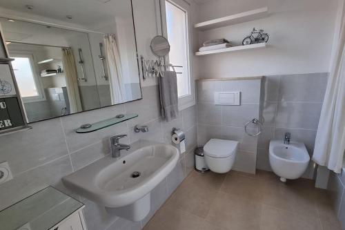 Un baño blanco con lavabo e inodoro. en OLIVA NOVA, playa, jardín, piscina, golf, MET, IDEAL FAMILIAS, en Oliva