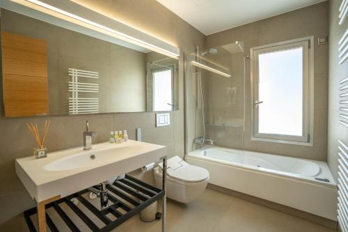 a bathroom with a sink and a toilet and a tub at Es Maiols Casa A in Can Furnet