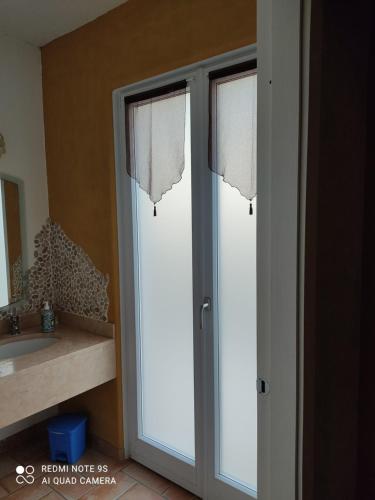 two glass doors with curtains in a bathroom at B&B Al Cristo in SantʼAmbrogio di Valpolicella