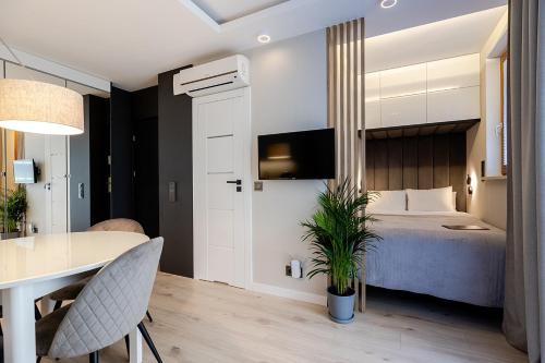 a bedroom with a bed and a table and a dining room at Apartment Wola, WI-FI, Smart Lock, Air Condition in Warsaw